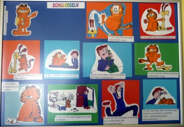 Das Bild zeigt die 10 Schulregeln. Die einzelnen Regeln sind mithilfe der Comicfigur Garfield illustriert und auch in Comicform dargestellt. Pro Regel gibt es eine Abbildung in der auch die anderen Charaktäre aus den Garfield-Comics drin vorkommen.